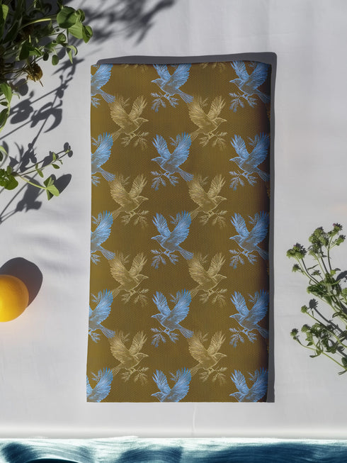 Set of four golden cloth napkins featuring alternating powder blue and metallic gold ravens in flight, sized 18x18 inches.